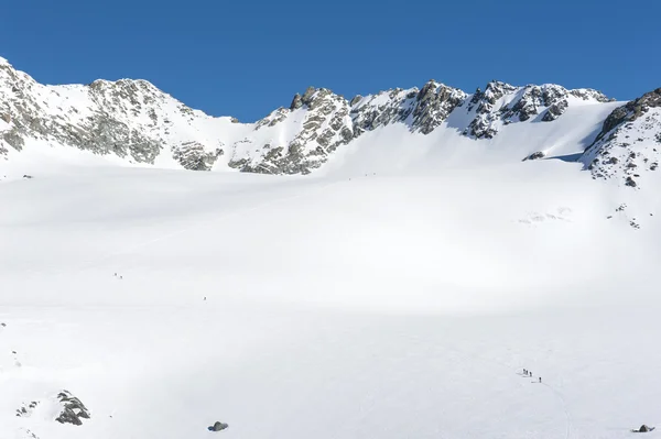 Panoramautsikt över en snöig backe med vandrare — Stockfoto