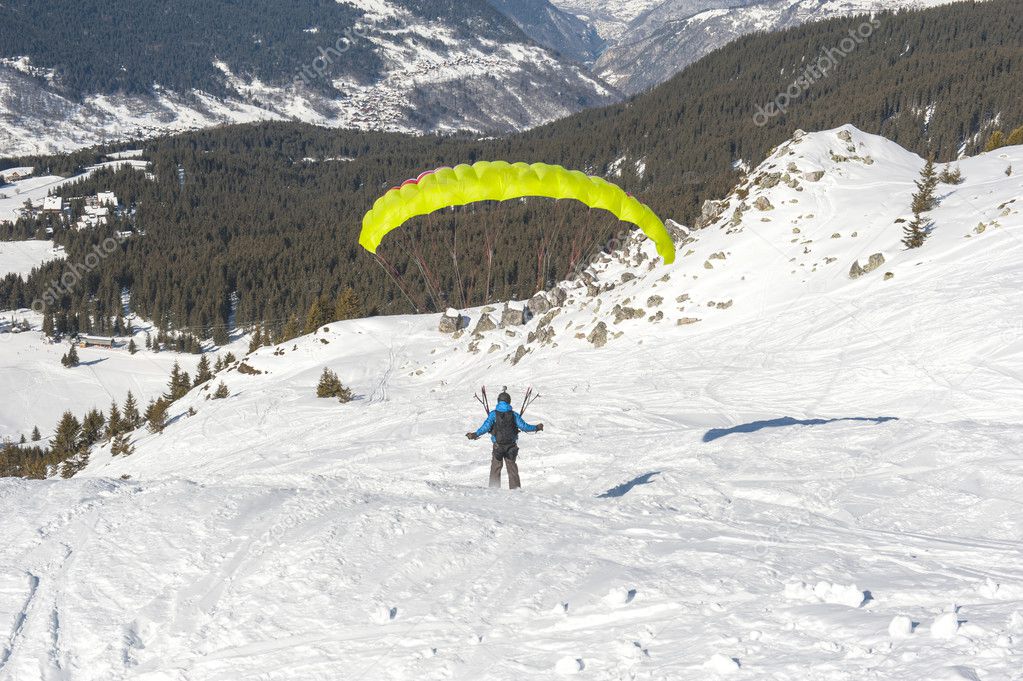 Paraglider taking off from a snowy slope