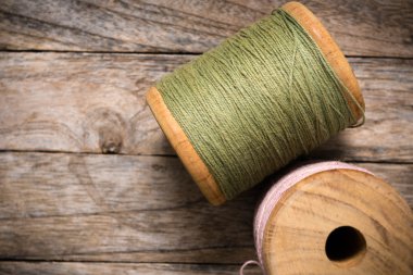 Reel pembe yeşil iplik sağ tarafı ahşap üzerine