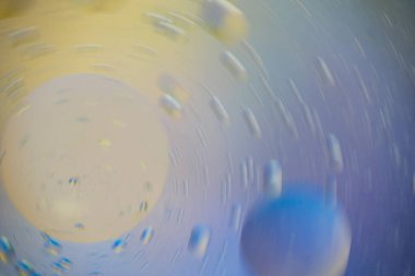 Etrafında hareketli iki büyük damla olan duvar kağıdı, çok küçük olanlar, renkler sarıdan maviye sorunsuzca geçer.