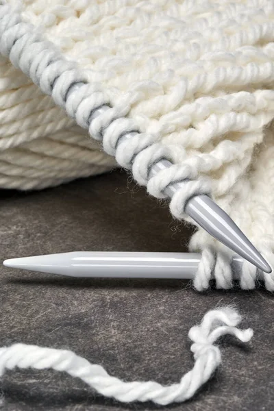 White wool knitted with spokes on gray background — Stock Photo, Image