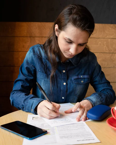 Modelo Menina Séria Assina Lançamento Uma Caneca Vermelha Mesa Caixa — Fotografia de Stock