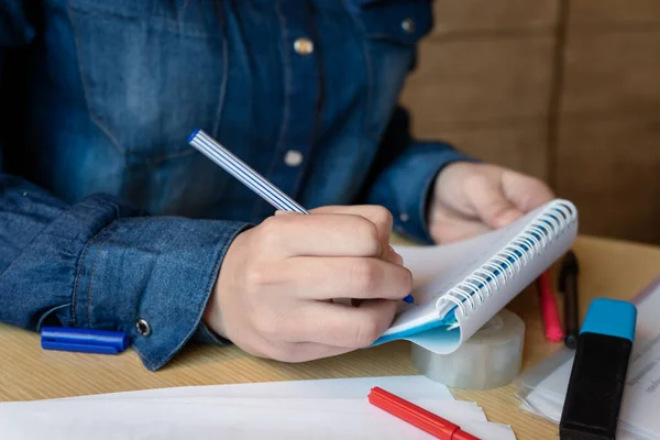 カフェに座っている青いデニムシャツの女の子は ペンでメモ帳にメモを作ります 各種チャート 粘着テープ付きシート — ストック写真