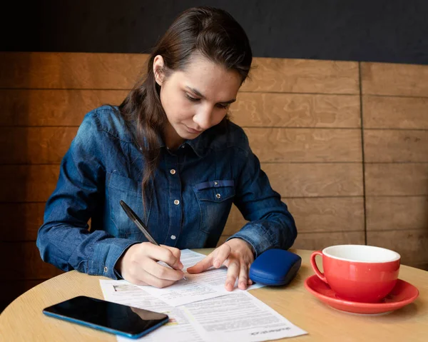 Modelo Menina Séria Assina Lançamento Uma Caneca Vermelha Mesa Caixa — Fotografia de Stock