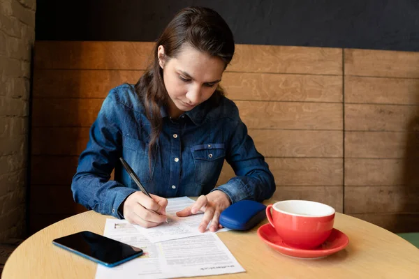 Modelo Menina Séria Assina Lançamento Uma Caneca Vermelha Mesa Caixa — Fotografia de Stock