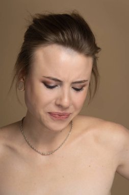 Tiksinç kız çerçeveden aşağı bakıyor. Tuhaf bir saç stili, iyi bir makyaj, kulak tıkacı, delinmiş bir burun, boynunda gümüş bir zincir var..