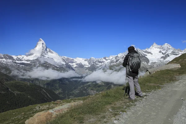 Trekker and lake and iconic Matterhorn range in switzerland — Stock Photo, Image