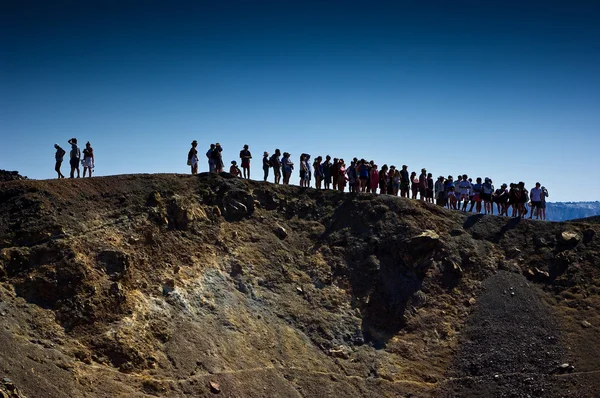 Tourists on the volcanic island named Nea Kameni. — Stock Photo, Image