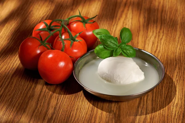 Mozzarella, tomatoes, basil, composition on a wooden table — Stock Photo, Image