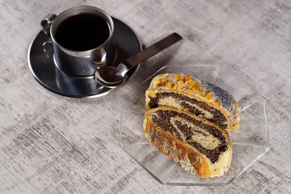 コーヒーとケーキ ケシの種巻きは 濃厚で濃厚で苦味のあるケシの種の充填とアイシンググレーズと砂糖漬けのオレンジピールで覆われた甘い酵母パン ヴィエンノゼリー のロールで構成されるペストリーです — ストック写真