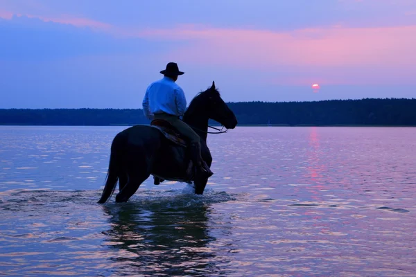 Rider på en häst titta på soluppgången — Stockfoto