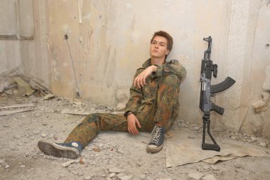 genç, savaş giysili oğlan ve bir tüfek, yumuşak hava tabancası