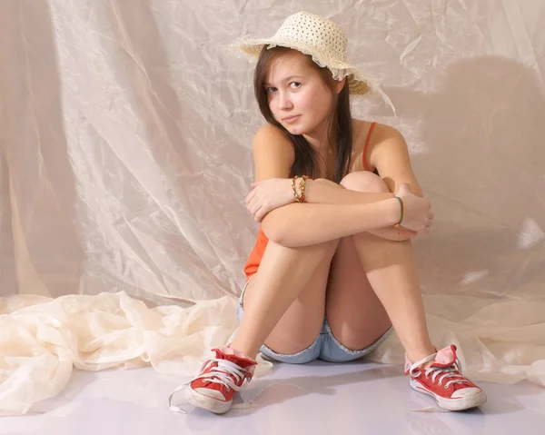 Teenager, girl in a sitting position and in a straw hat — Stock Photo, Image