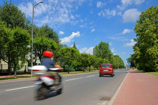 Городская сцена, скутер и автомобили, едущие по улице в городе, пешеходный переход — стоковое фото