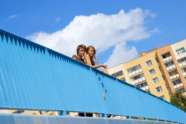 Jongen en meisje, tieners staan achter de verhoogde loopbrug balustrade — Stockfoto