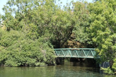 Nehrin üzerinden geçen yeşil metal bir köprü..