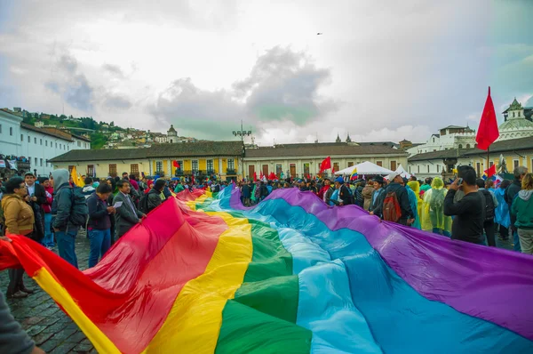 Quito, Équateur - 27 août 2015 : Peuples autochtones arborant un grand drapeau de couleur arc-en-ciel lors de manifestations de masse contre le gouvernement — Photo