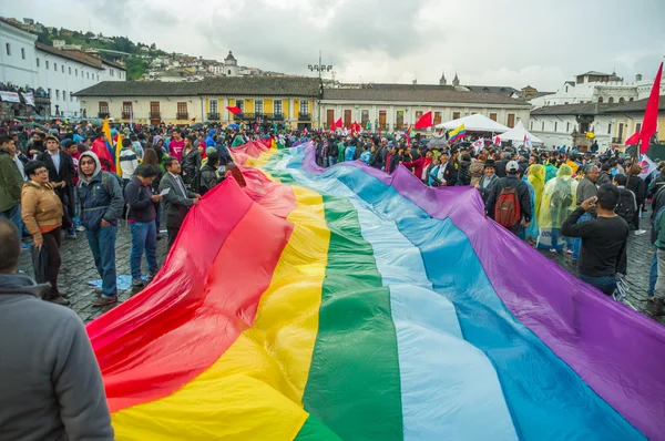 Quito, Équateur - 27 août 2015 : Peuples autochtones arborant un grand drapeau de couleur arc-en-ciel lors de manifestations de masse contre le gouvernement — Photo