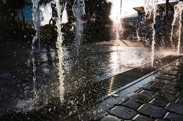 Cascata moderna e beutifull con sole nella parte posteriore. Gocce d'acqua ballare — Foto Stock