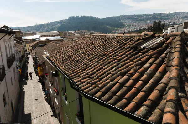 Telhados e blocos de telha rua atrás bela colina e cidade — Fotografia de Stock