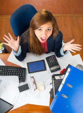 Ofis Masası ile tarafından oturan genç kadın dışarı, açı yukarıda görüldüğü gibi kamera etkileşen bakarak forma malzemeleri