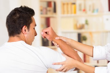 Arkadan holding kadın Fizyo terapist eller ile görülen erkek hasta kol mans