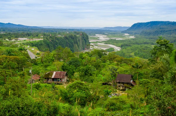 Fantastic overview of amazon jungle valley with river and waterfalls in the distance, some simple small houses located sorrounded by forest — Stock Photo, Image