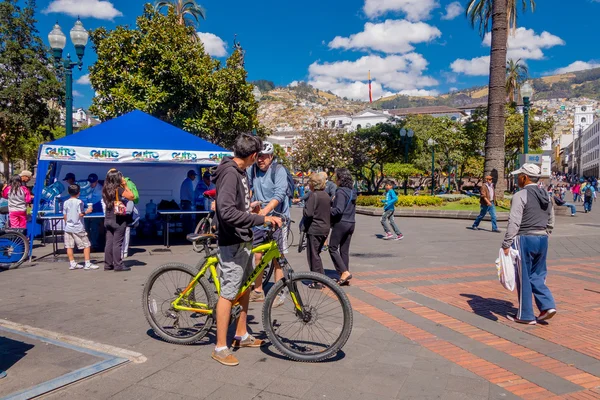 QUITO, ECUADOR - MARZO 23, 2015: Ciclista no identificado se detiene por un tiempo en la plaza de la independencia de Quito para beber agua y buscar este gran lugar —  Fotos de Stock