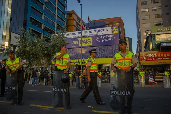Quito, Ekvator - 7 Nisan 2016: anti Shyris Avenue, güzel mavi gökyüzü ve binaların arka plan hükümet Protesto huzurlu bakan bekleyen polis — Stok fotoğraf