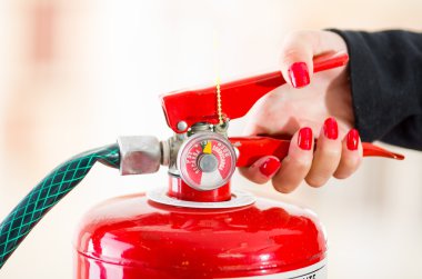 Closeup woman hands with red nailpolish showing how to operate fire extinguisher clipart