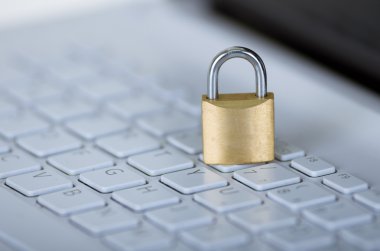 Beyaz bilgisayar klavyesi üzerinde oturan küçük asma kilit, çevrimiçi güvenlik konsepti