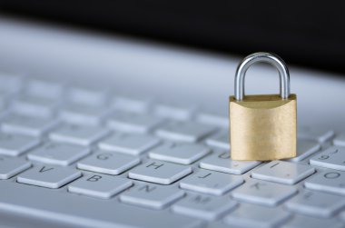 Beyaz bilgisayar klavyesi üzerinde oturan küçük asma kilit, çevrimiçi güvenlik konsepti