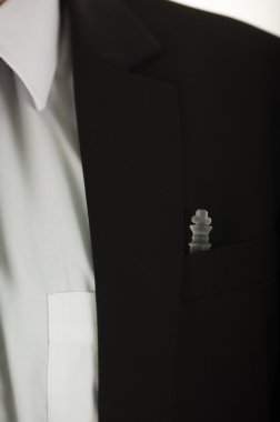 Portre siyah ceket göğüs cebi içinde beyaz gömlek oturan cam satranç parça ile takım elbise ve kravat görünür