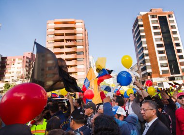 Quito, Ekvator - 7 Nisan 2016: Grup insanlar Holding protesto işaretler, polis ve anti Shyris Avenue hükümet protesto sırasında gazeteciler ile balonlar