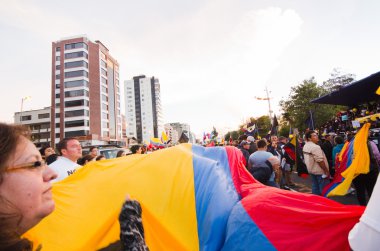 Quito, Ekvator - 7 Nisan 2016: Bir grup insan bir çok büyük Ekvador bayrak, protesto ve hükümet protesto anti sırasında gazeteciler Shyris caddede görüntüleme.