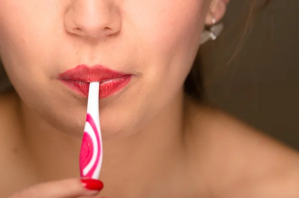 Closeup young womans mouth closed with toothbrush sticking out — Stock Photo, Image