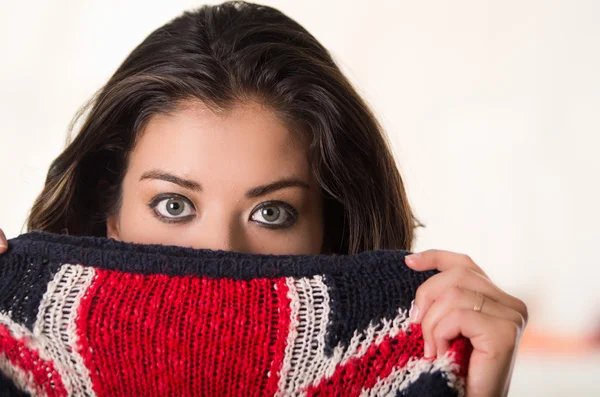 Headshot attractive brunette facing camera covering half her face with british flag patterned clothing, white studio background — Stock Photo, Image