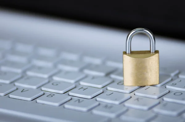 Small padlock sitting on white computer keyboard, online security concept — Stock Photo, Image