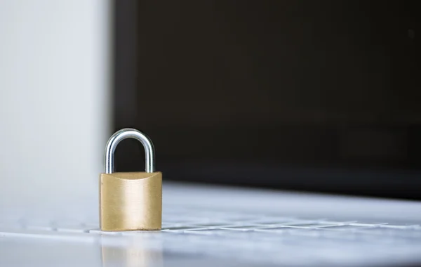 Small padlock sitting on white computer keyboard, online security concept — Stock Photo, Image