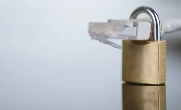 Small padlock with ethernet cable going through it, internet security concept — Stock Photo, Image