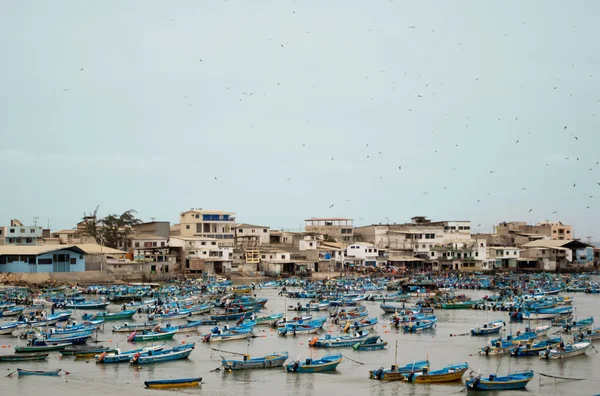 Salinas, Ecuador - March 22, 2016: Small local blue fishing boats spread out on the water in front of beach, charming and cozy fishermen village — Stock Photo, Image