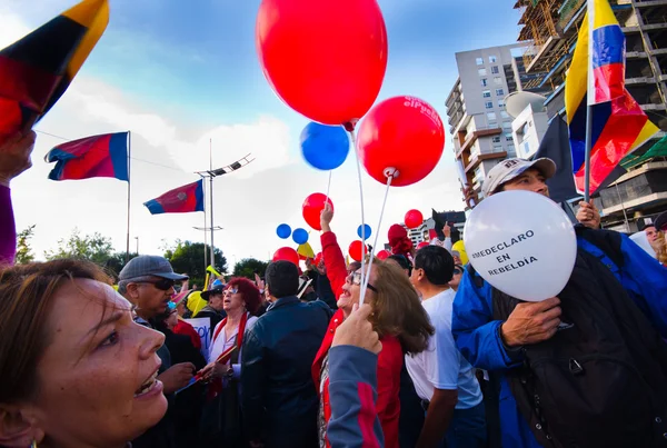 Кито, Эквадор - 7 апреля 2016 года: Группа людей, держащих плакаты протеста, воздушные шары с полицией и журналистами во время антиправительственных протестов на проспекте Ширис — стоковое фото