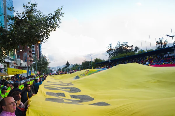 Quito, Ecuador - 7 April 2016: Groep mensen weergave van een zeer grote Ecuadoraanse vlag, protest borden en journalisten tijdens anti regering protesten in Shyris Avenue. — Stockfoto