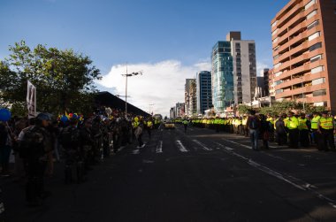 Quito, Ekvator - 7 Nisan 2016: anti Shyris Avenue, güzel mavi gökyüzü ve binaların arka plan hükümet Protesto huzurlu bakan bekleyen polis