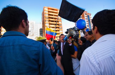 Quito, Ekvator - 7 Nisan 2016: Grup insanlar Holding protesto işaretler, polis ve anti Shyris Avenue hükümet protesto sırasında gazeteciler ile balonlar