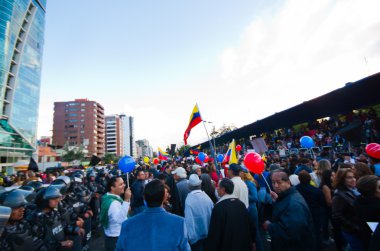 Quito, Ekvator - 7 Nisan 2016: Grup insanlar Holding protesto işaretler, polis ve anti Shyris Avenue hükümet protesto sırasında gazeteciler ile balonlar