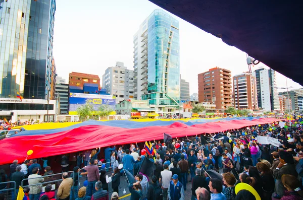Quito, Ekwador - 7 kwietnia 2016: Grupa ludzi wyświetlanie bardzo duża flaga Ekwadoru, oznaki protestu i dziennikarzy podczas anty rząd protesty w Shyris Avenue. — Zdjęcie stockowe