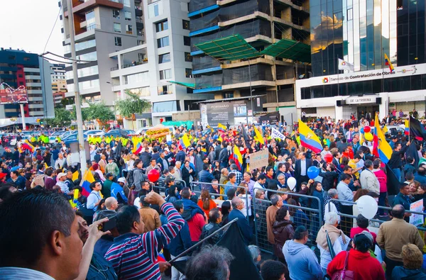 Quito, Ecuador - 7 de abril de 2016: Grupo de personas mostrando una gran bandera ecuatoriana, pancartas de protesta y periodistas durante protestas contra el gobierno en la Avenida Shyris . — Foto de Stock