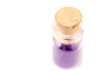 Küçük şişe konteyner ile mor çivi renk içinde ve beyaz yüzey üstüne mantar