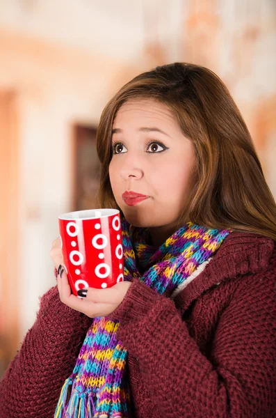 Bella giovane donna bruna che indossa giacca rossa e sciarpa, con in mano una tazza di bevanda calda — Foto Stock